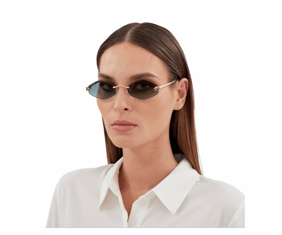 Stylish cat-eye sunglasses with gold frame and gradient lenses, worn by woman in white shirt