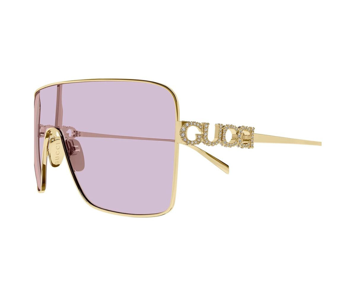 Luxury gold-framed sunglasses with pink lenses and crystal-embellished Gucci logo on arms